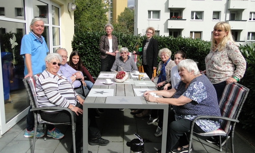 Die Teilnehmer der Demenzgruppe freuen sich mit Manuela Patricny, Sozialarbeiterin und Pädagogin im Paritätischen Wohl- fahrtsverband, Praktikantin Laura Barth, Geschäftsführerin Christine Köhler-Riebau, Sparkassensprecherin Alexa von der Brelje, Auszubildende Anastasia Mantarli und Pflegerin Gabriele Steckhahn über die neuen Gartenmöbel. Foto: Sparkasse Gifhorn-Wolfsburg