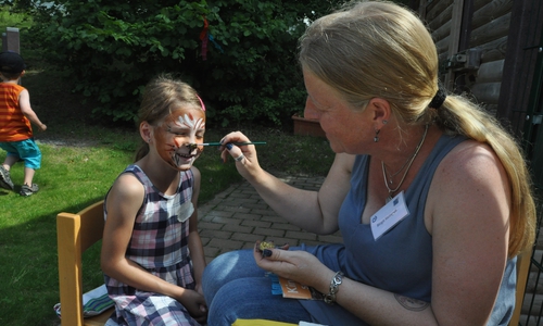Frühförderin Birgit Steingaß schminkte Fest-Besucherin Julia ein Löwengesicht. Fotos: Lebenshilfe