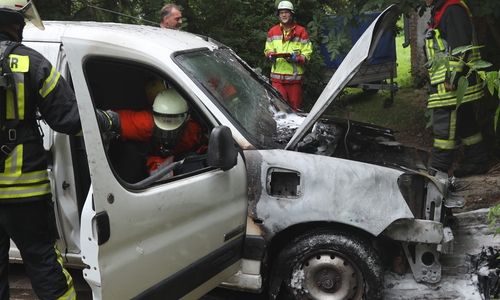 Einsatzkräfte inspizieren das ausgebrannte Wrack. Foto: Rudolf Karliczek