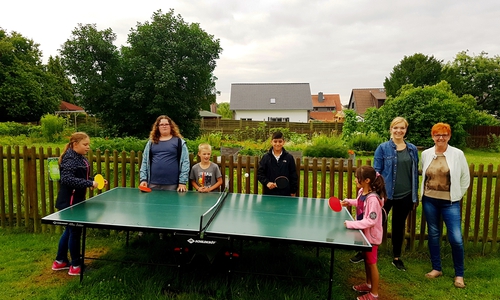 Die Ulmen-Kinder Sarah (von links), Jennifer, Jonas, Orhan, Shina sowie Susanne Pensler und Katrin Lettow freuen sich über die Tischtennisplatte im Gemeinschaftsgarten. Foto: Ulme