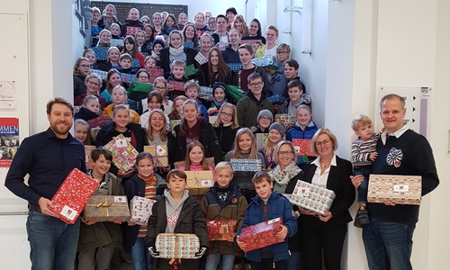 Lehrer Kevin Müller (links) und Schulleiterin Dr. Ute Krause (rechts) übergeben zusammen mit Schülerinnen und Schülern der Großen Schule Martin Koch vom Round Table (rechts) 140 Weihnachtspäckchen. Foto: Große Schule