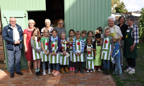 Die Hortgruppe der Kindertagesstätte Varietà und ihre Erzieherinnen Kirsten Raschka (2. v. l.) und Ramona Torka (4. v. l.) freuen sich mit den Ehrenamtlichen des Gärtnermuseums auf das Apfelfest. Foto: Dr. Rolf Stippler