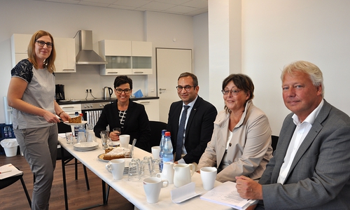 Die Einrichtung ist noch nicht komplett, aber Kaffee und Kuchen schmecken trotzdem schon. Von links: Justyna Zdanowicz (Projektkoordinatorin AWO-Nachbarschaftsladen), Karin Stemmer (Vorständin Braunschweiger Baugenossenschaft), Rifat Fersahoglu-Weber (AWO-Vorstandsvorsitzender), Christiane Jaschinski-Gaus (Bezirksbügergermeisterin Heidberg-Melverode), und Torsten Voß (Vorsitzender der Geschäftsführung Nibelungen-Wohnbau) kurz vor der feierlichen Eröffnung des Nachbarschaftsladens. Foto: AWO-Bezirksverband Braunschweig e. V.