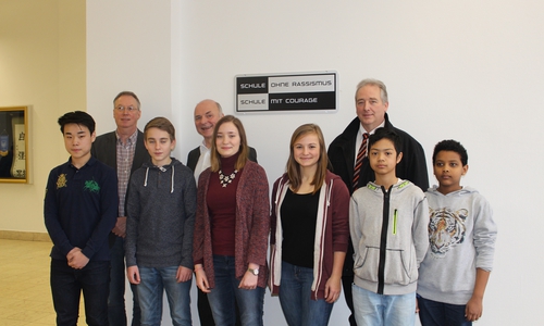 Studiendirektor Michael Habenbacher, Schulleiter Hartmut Frenk und CDU-Landtagsabgeordneter Frank Oesterhelweg mit Schülern der Großen Schule vor der neuen Plakette in der Eingangshalle.  