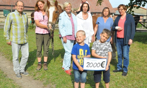 Bei der Spendenübergabe (von links): Lebenshilfe-Vorsitzender Joop van den Heuvel, Corinna Weiß mit Sam, Inge Nicolaus (Präsidentin des Kiwanis-Fördervereins), Angelika Ripken (stellvertretende Präsidentin des Kiwanis-Fördervereins), Kindergarten-Leiterin Kristine Voigt und Almuth Ottmer, Präsidentin des Kiwanis-Clubs mit den Kindern Ava (auf Sam) sowie Jason und Thammy. Foto: Lebenshilfe