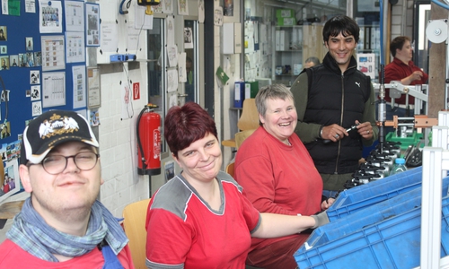 Samad Azizi (h.r.) unterstützt Menschen mit Behinderung bei der Montage von Bauteilen. Fotos: Lebenshilfe Gifhorn