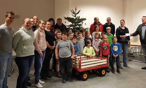 Kinderfeuerwehrwartin Meike-Maren Beinert bedankt sich unter den Augen der Kinderfeuerwehrmitglieder und der Lindener Ortswehrführung bei Ortsbürgermeister Kersten Meinberg. Foto: Feuerwehr Linden