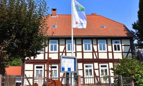 In Winnigstedt wird die Bewertungs-Kommission zum Wettbewerb „Unser Dorf hat Zukunft“ mit Spannung erwartet. Die Winnigstedter haben am Gemeindehaus eine Fahne mit dem Logo des Dorfwettbewerbs geflaggt. Foto: Gemeinde Winnigstedt 