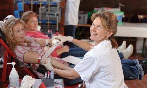 Eine Helferin des DRK-Blutspendedienstes und eine Spenderin während der Blutspende. Foto: DRK
