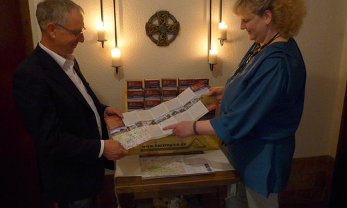 Die Geopark-Faltblätter liegen seit kurzem auch im Gasthaus „Zur Queste“ in Questenberg in der Gemeinde Südharz aus. Zu sehen sind Geoparkleiter Dr. Klaus George und Gastwirtin Liane Gast. Foto: RVH
