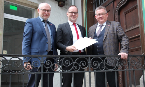 Der Niedersächsische Kultusminister Grant Hendrik Tonne überreicht die Bescheide an Kammerpräsident Detlef Bade und Hauptgeschäftsführer Eckhard Sudmeyer. Foto: Handwerkskammer Braunschweig-Lüneburg-Stade