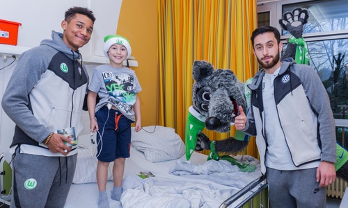 Felix Uduokhai und Yunus Malli auf Krankenbesuch – Wölfi darf natürlich nicht fehlen. Foto: VfL Wolfsburg