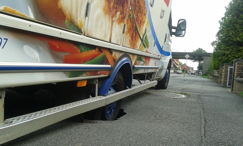 Durch das entstandene Loch im Asphalt wurde die Kanalisation sichtbar. Foto: Polizei