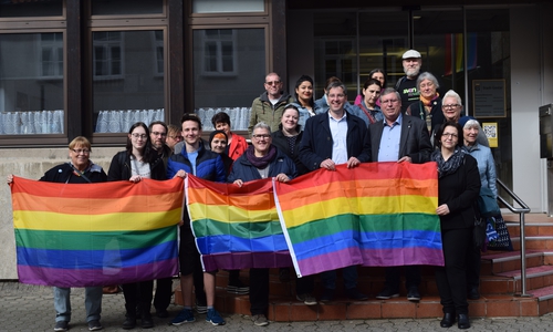 Oberbürgermeister Dr. Oliver Junk, Erster Stadtrat Burkhard Siebert (beide hinter der rechten Regenbogenfahne), Vereine, Arbeitsgruppen, Mitarbeiterinnen und Mitarbeiter der Verwaltung sowie weitere Engagierte unterstützen das Signal der Regenbogenfahne vor Goslars Stadtverwaltung: Toleranz, Solidarität und Vielfalt. Foto: Stadt Goslar