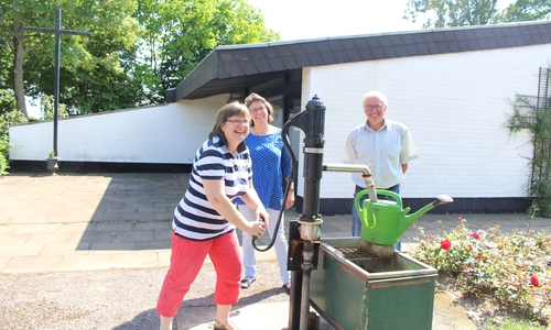 Kristina Johns vom Kirchenvorstand, Pastorin Katharina Pultke und Ortsbürgermeister Horst Prediger an der Wasserpumpe vor der Kapelle in Leinde. Foto: Jan Borner