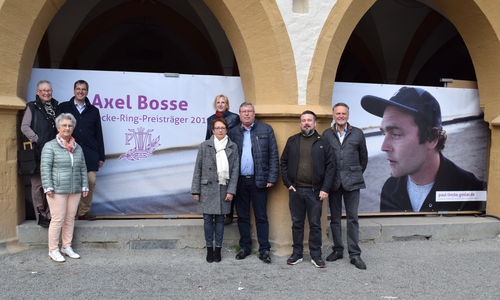 Dr. Oliver Junk, Susanne Roßdeutscher Giovanni Graziano sowie der Freundeskreis Paul-
 Lincke-Ring präsentieren die Planen mit Bosses Gesicht unter den Rathausarkaden. Fotos: Stadt Goslar