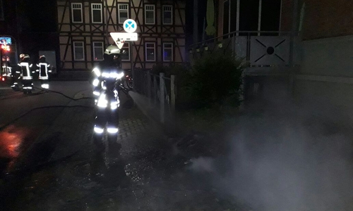 Einsatzkräfte beim Löschen der Altpapiertonne. Foto: Feuerwehr