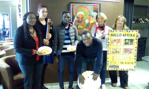 Vorbereitungsteam „Hallo Afrika!“ vor einem Kunsthandwerkerbild in der KUBA-Kulturhalle von li.: 
Abena Mankosa Apea-Otu-Kerin, Elena Zunker, Abdelgami Ali Adam, Jean-Jacques Kimbunda, Hanne Rüssel-Wagner, Beatrix Kolb. Foto: Bündnis gegen Rechtsextremismus WF