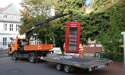 Der Kran platziert die umfunktionierte Telefonzelle "Büchertreff" an ihren rechtmäßigen Platz. Foto: Jürgen Kumlehn