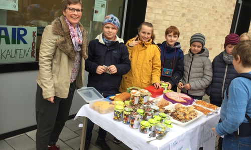 Lehrerin Jutta Schnippe mit den Schülern beim Kuchenverkauf. Foto: GiS