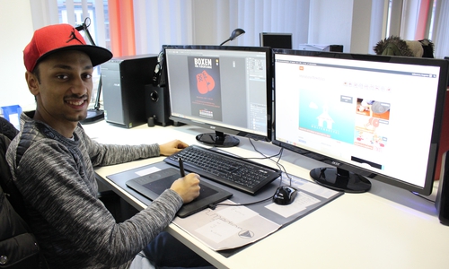 Besnik Salihi erstellt am Computer die nächsten Flyer und Plakate. Foto: Max Förster