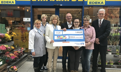 Edeka-Markt-Inhaber Marco Bahrs (Mitte) und Mitarbeiterinnen übergeben den offiziellen Spendenscheck zugunsten des Kindernetzwerks United Kids Foundations an Claudia Kayser (3. v. li) und Frank Theuerkauf (rechts) von der Volksbank BraWo. Foto:
Volksbank BraWo