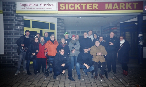 Ein Teil der Besucher beim „Sickter Neujahrstreff“ vor dem Penny-Einkaufszentrum. Im Bild:  Altbürgermeister Dieter Lorenz (Mitte, auf Rollator) im Gespräch mit Besuchern.
Foto: Lothar Köchy