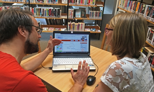 Auszubildender Benjamin Heibutzki und die Fachangestellte für Medien- und Informationsdienste Susann Mattern mit der geöffneten Homepage der Onleihe des Verbundes NBib24. Foto: Landkreis Peine 