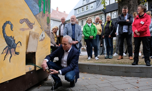 Am Donnerstagnachmittag drehte Landrat Thomas Brych im Beisein zahlreicher Zuschauer den Hahn auf, um das Schmelzwasser aus der bestens gedämmten „Villa Wohlig“ ablaufen zu lassen. Dies zog sich übrigens hin. Bis die 570 Liter Schmelzwasser abgelaufen waren, vergingen vier Stunden. Foto: Landkreis Goslar
