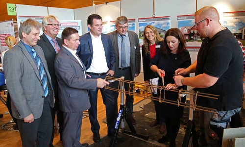 Samtgemeindebürgermeisterin Anja Meier (Boldecker Land) testete 2017 am Stand der Baugesellschaft Hans Drewes ihr handwerkliches Geschick während des Messerundgangs. Mit im Bild (von links): Bernd Manthey, Allianz für die Region GmbH, Gerald Witt, Agentur für Arbeit Helmstedt, Oliver Syring, Allianz für die Region GmbH, Matthias Nerlich, Bürgermeister Gifhorn, Andreas Standop, Jobcenter Gifhorn, sowie Mitarbeiter der Baugesellschaft Hans Drewes. Foto: Allianz für die Region GmbH/Matthias Leitzke 