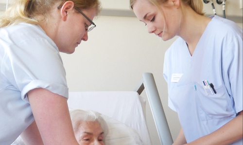 Die Stationsleiterinnen Rebecca Ebert (links) und Janina Giesbert (rechts) versorgen eine Patientin auf der Station 2.5. Foto: Helios Klinikum