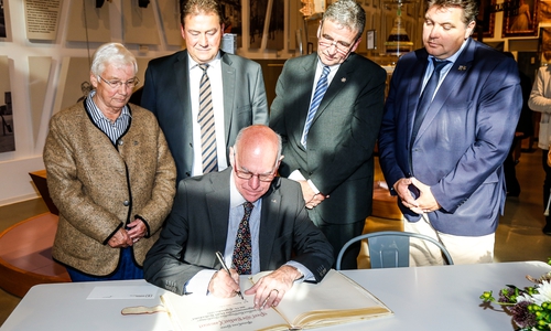 Norbert Lammert trägt sich in das Goldene Buch der Stadt ein. Ratsvorsitzende Hiltrud Bayer, MdB Uwe Lagosky, Bürgermeister Thomas Pink und stellvertretender Landrat Uwe Schäfer schauen ihm über die Schulter. Foto: Stadt Wolfenbüttel