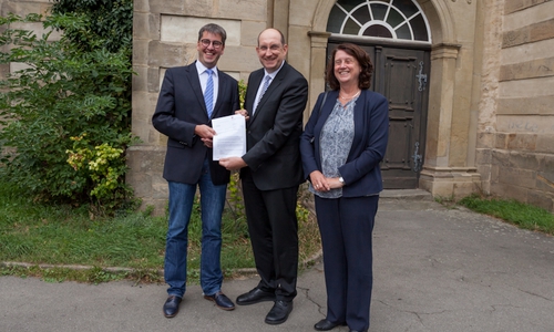 Oberbürgermeister Dr. Oliver Junk (links) und Marion Siegmeier freuen sich über den Förderbescheid.  Der Landesbeauftragte für regionale Landesbeauftragte Braunschweig, Matthias Wunderling-Weilbier, überbrachte diesen Anlässlich der Augnahme des Gebiets "Altstadt - Östlicher Teil" in das Förderprogramm "Städtebaulicher Denkmalschutz" am Montag persönlich. Foto: Alec Pein