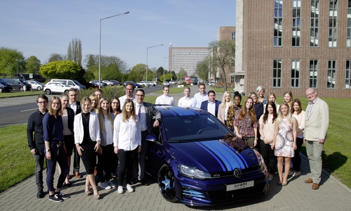 Die Top-Azubis stehen mit Ihren Gratulanten am Showcar Golf GTI First Decade, den Auszubildende nach eigenen Vorstellungen entworfen, entwickelt, aufgebaut und beim GTI-Treffen 2017 am Wörthersee präsentiert haben. Foto: Volkswagen