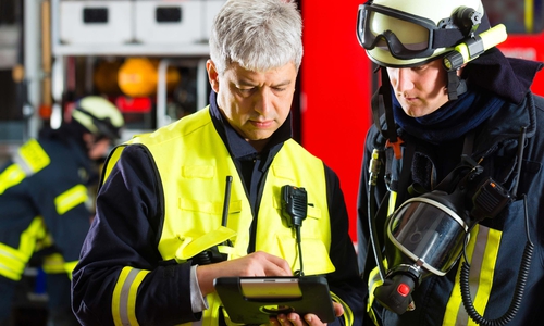 Zwei Feuerwehrmänner schauen auf ein Tablet. Symbolfoto: Agentur für Arbeit