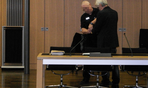Ein Justizbeamter nimmt Hilmer K. vor der Urteilsverkündung die Handfesseln ab.
Foto: Klaus Knodt