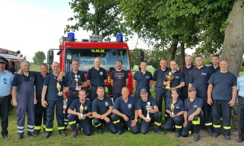 Von links: Gemeindebrandmeister Sascha Kehlau, 3. Platz Danndorf, 1.Platz Danndorf/Grafhorst, 2. Platz Wahrstedt, und stellvertretender Gemeindebrandmeister Andreas Wogatzki posieren vor dem Feuerwehrfahrzeug in Grafhorst. Foto: FF SG Velpke
