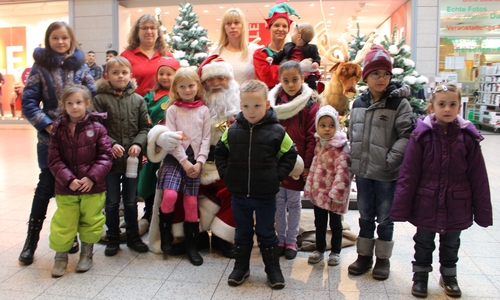 Maria-Theresia Schrader vom Mieterbeirat und Karina Karger vom Center-Management begrüßten zusammen mit vielen Kindern den Weihnachtsmann und seine Gehilfen. Foto: Alexander Dontscheff