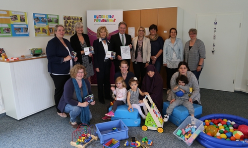 (Hinten stehend von links): Bianka Köllner (Abteilungsleiterin Kindertagesbetreuung Stadt Wolfsburg), Marion Herrfurth (Abteilungsleiterin Prävention, Stadt Wolfsburg), Claudia Kayser (Leiterin der Direktion Wolfsburg, Volksbank BraWo), Thomas Fast (Vorstandsvorsitzender der Volksbank BraWo Stiftung), Stefanie Seeck (Koordinatorin des Familienzentrum St. Annen) sowie pädagogische Fachkräfte des Projekts und Projektteilnehmer sowie (vorne links) Elke Mrosek (Verantwortliche für Familienzentren in Wolfsburg, Stadt Wolfsburg). Foto: Stadt Wolfsburg