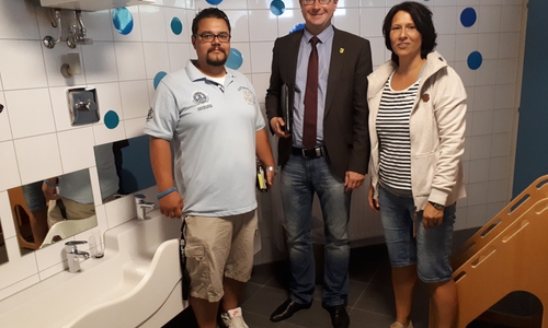 Sicktes Bürgermeister Marco Kelb (CDU) lässt sich die abgeschlossenen Sanierungsarbeiten eines Sanitärraumes in der KiTa Arche Noah von Samtgemeindemitarbeiter Frank Wasserkampf (links) und KiTa-Leiterin Sandra Vetter erläutern. Foto: Gemeinde Sickte