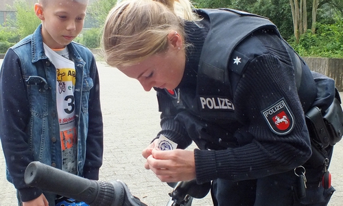 Eine Polizeikommissarin versieht das Rad eines Schülers des Gymnasiums Julianum mit einer ADAC Prüfplakette. Foto: Kreisverkehrswacht Helmstedt e.V.