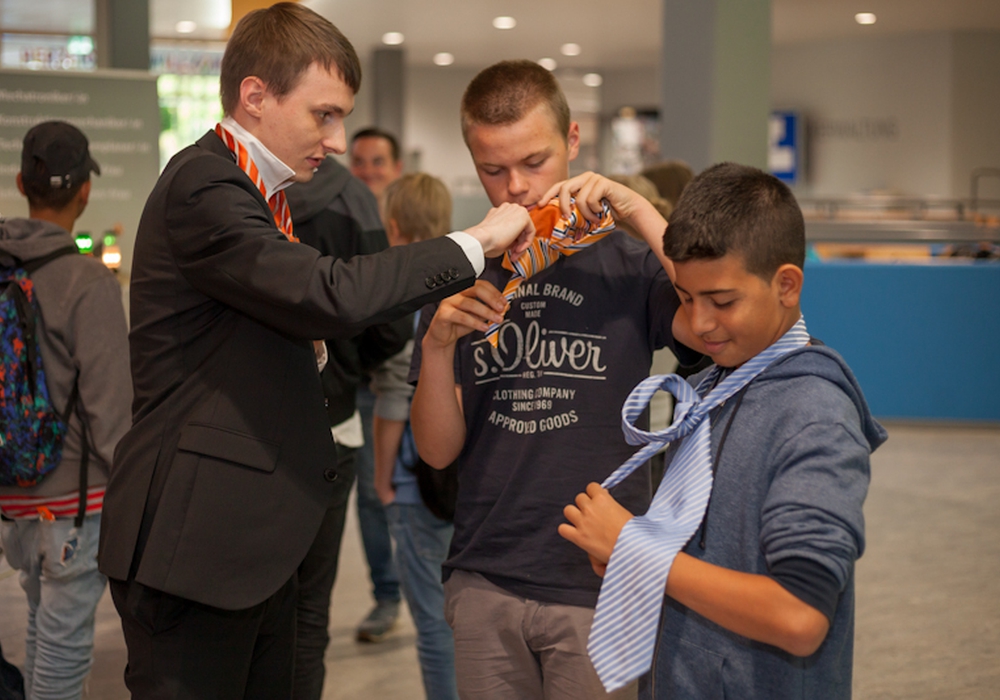 Praktische Tipps: Yannick Samlowitz und Faruk Eliacik lassen sich beim Berufeparcours in der Oberschule Langelsheim von Volksbank-Mitarbeiter Christoph Ihme das Krawattenbinden zeigen. Foto: 
