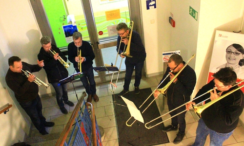 Neuerkeröder Posaunenchorspieler in einem Treppenhaus zwischen zwei Stationen. Mit dabei auch eine Tuba, die durch die Treppe verdeckt wird. Foto: privat