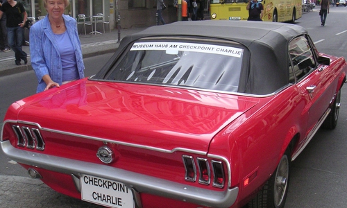 Regina Albrecht am Checkpoint Charlie mit dem Fluchtfahrzeug. Foto: privat
