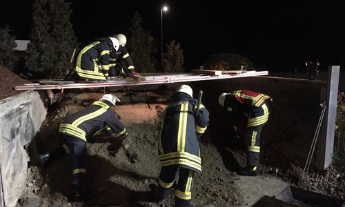 Mehrere Feuerwehrleute während der Rettungsaktion am Kieshaufen. Es galt mit Schaufeln
und Lanzen einen aufgeschütteten Haufen Kies zu durchsuchen. Foto: Tobias Stein/Philipp Meyer
