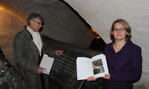 Herausgeber Prof. Dr. Christoph Helm und Pfarrerin Ina Naumann-Seifert vor einem Sarkophag in der Welfengruft. Foto: Jan Borner