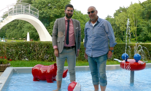 Rechtsanwalt Sebastian Gutt und Martin Lehmann vom Waldbad-Förderverein (v.li.) tauchen ihre Füße ins neue Babybecken, das noch mit einem Sonnenschutz versehen werden soll. Foto: Kanzlei Sticherling Simon & Partner