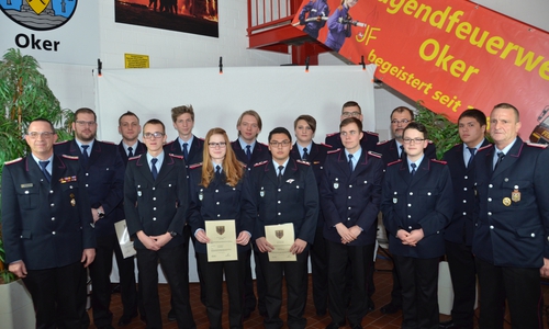Neue Feuerwehrmitglieder und Beförderte des Abends mit Stadtbrandmeister Christian Hellmeier (links) und Ortsbrandmeister Hans-Jürgen Bothe (rechts). Foto: Freiwillige Feuerwehr Oker