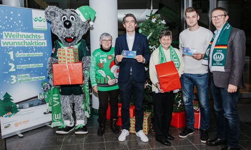 Maskottchen Wölfi, Elke Zitzke (Wolfsburger Tafel), VfL-Geschäftsführer Michael Meeske, Brigitte Lotz (Wolfsburger Tafel), Robin Knoche und Oberbürgermeister Klaus Mohr (vlnr) gaben den Startschuss für die Weihnachtswunschaltion 2019. Foto: VfL Wolfsburg