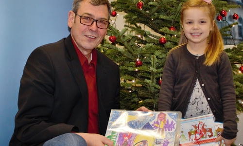 Matthias Möhle bedankte sich bei Juna Wolf mit einem Gutschein für ihr Kunstwerk, das in diesem Jahr die Weihnachtspostkarte ziert. Foto: SPD